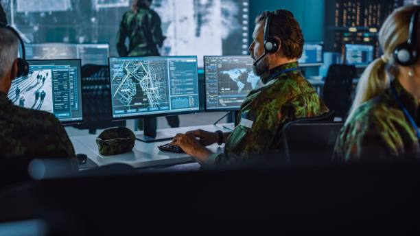 istock Military Surveillance Officer Working on a City Tracking Operation in a Central Office Hub for Cyber Control and Monitoring for Managing National Security, Technology and Army Communications. 1355656652