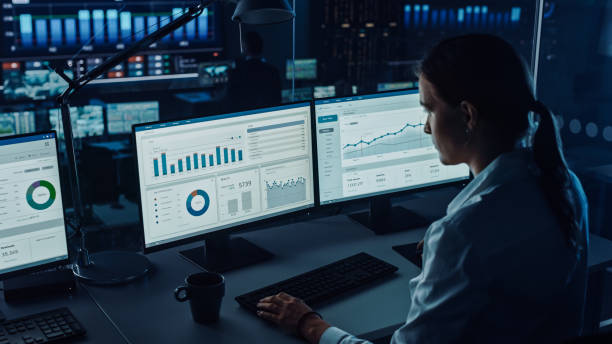 profesjonalni analitycy danych finansowych pracujący w nowoczesnym biurze monitorującym z kanałem analizy na żywo na dużym ekranie cyfrowym. monitoring sali ze specjalistami ds. finansów siedzi przed komputerami. - center data computer network surveillance zdjęcia i obrazy z banku zdjęć