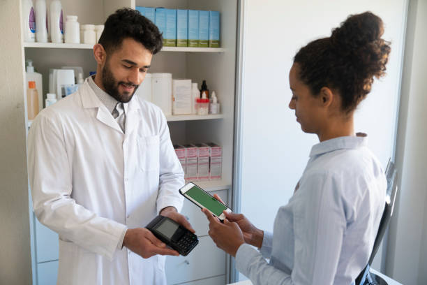 istock African American female customer paying with smartphone at pharmacy 1355658982