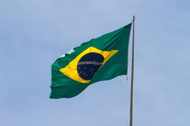 istock Brazil flag outdoors with beautiful blue sky 1355661020