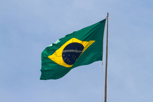 Brazil flag outdoors with beautiful blue sky stock photo