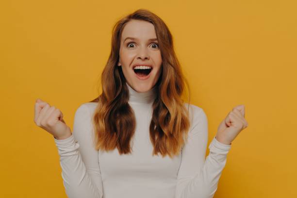 istock Young emotional stunned female student making wow face expression and clenching fists 1355661840
