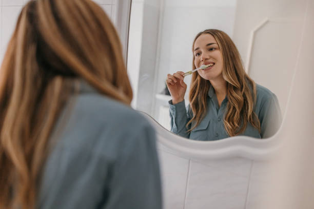 istock Beautiful woman brushing teeth 1355662853