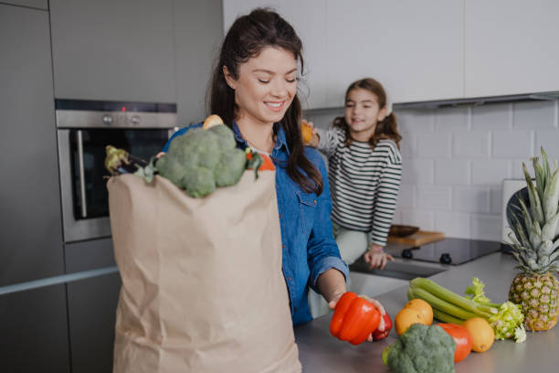 istock Mother and daughter returning from groceries shopping 1355663545