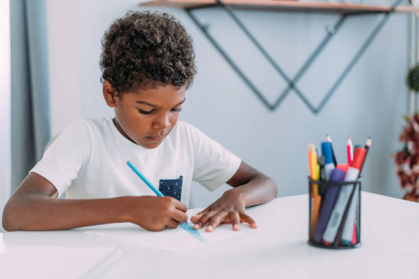 cute boy relaxing at home and drawing on a paper. - black pencil fotos imagens e fotografias de stock