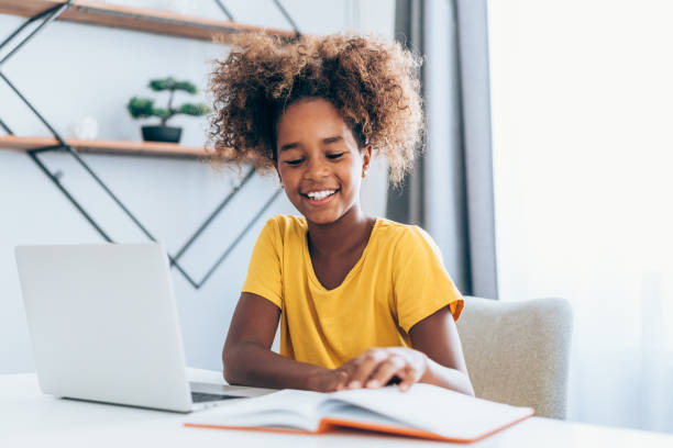 istock Schoolgirl studying with video online lesson at home. 1355666534