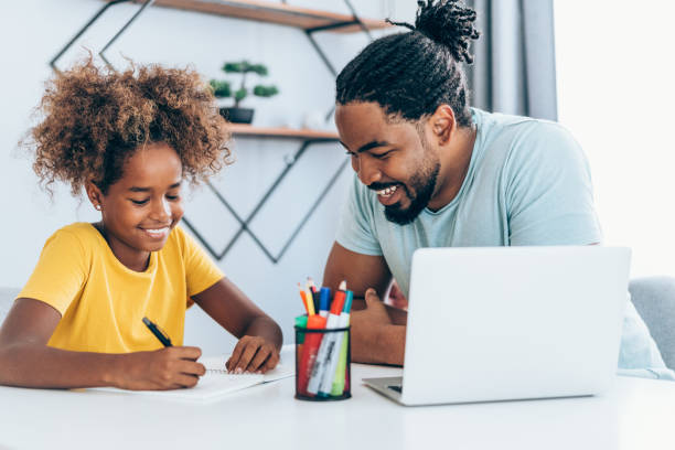 istock Father and daughter studying online at home. 1355666642