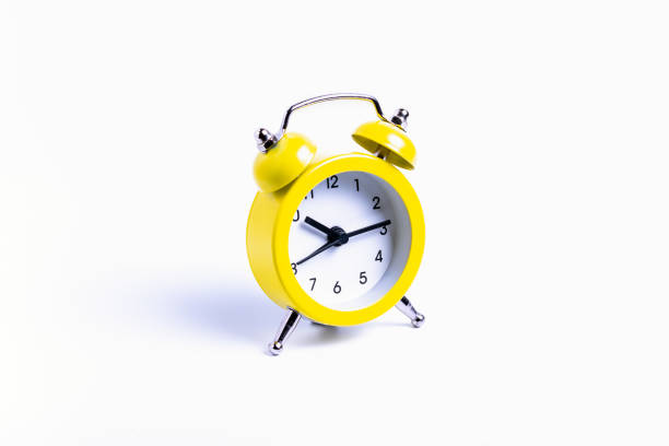 istock isolate, yellow alarm clock on white background, close-up 1355667042