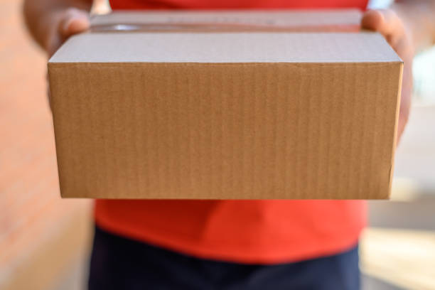 istock Close-up of cardboard package. Home delivery concept 1355667192