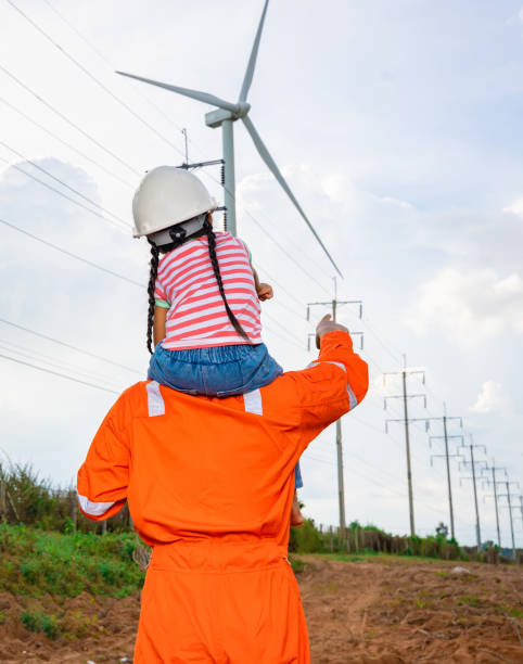 Engineers take daughter on a tour of wind power plants. Wind turbines are an alternative electricity source to be sustainable resources in the future. Clean energy concept saves the world stock photo