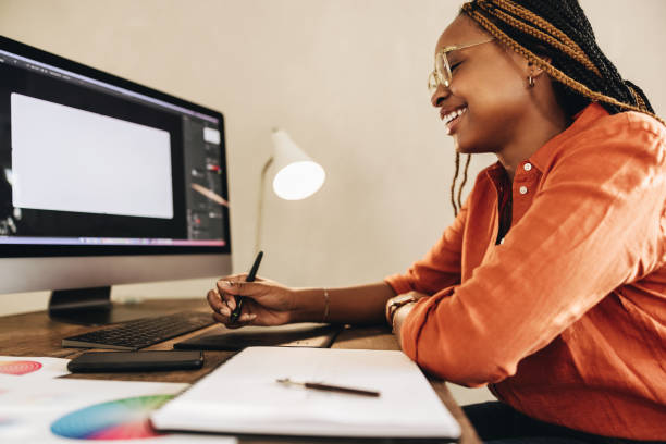 istock Cheerful female designer working at her desk 1355668348