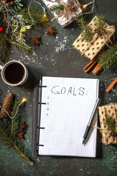 istock Open planner Notebook with empty goals list and cup of coffee on xmas dark stone tabletop. New year or christmas planning concept. Flat lay. 1355669982