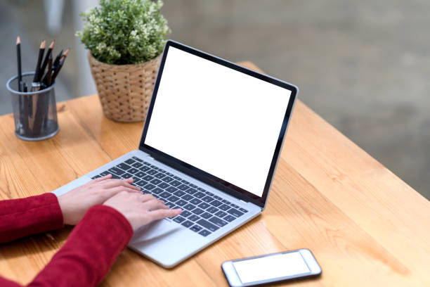 istock Close up. woman hand using and typing on laptop blank white screen in office. Mock up. 1355670057