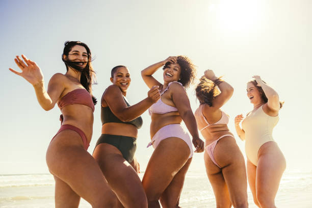 istock Carefree friends dancing at the beach 1355671275
