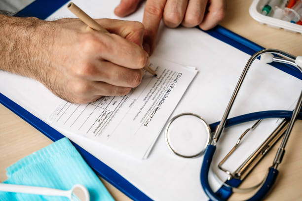 istock Vaccination record card. Vaccination form during the coronavirus epidemic on the doctor's table in the hospital. 1355674932