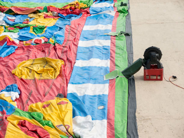 istock Big color inflatable castle on ground with electric air blower on plastic box side view 1355675229