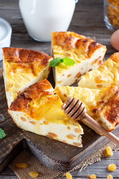 istock Cottage cheese casserole with raisins on wooden background 1355675291