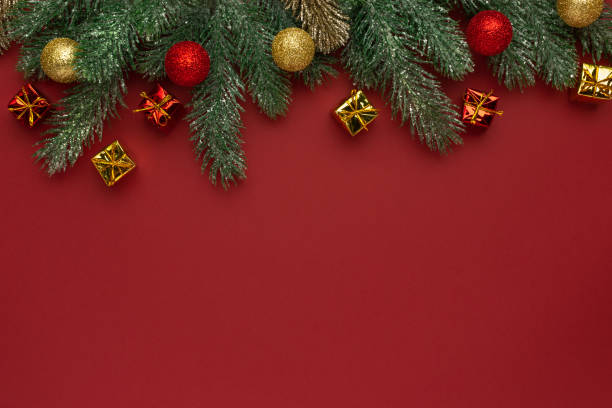 istock Christmas composition. Coniferous branches and decorative ornaments on a red background. 1355677485