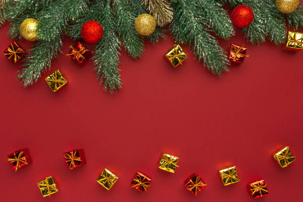 istock Christmas composition. Coniferous branches and decorative ornaments on a red background. 1355677687