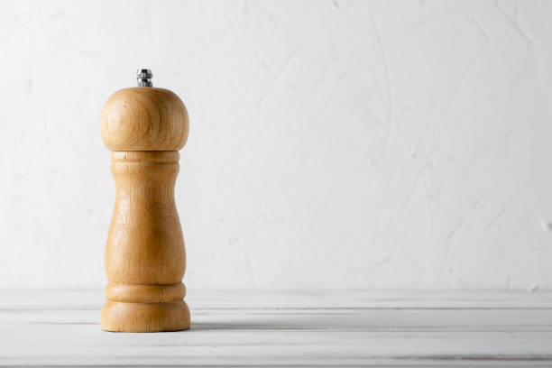 Wooden pepper shaker grinder on a white wooden background. Wooden pepper shaker grinder on a white wooden background. coffee grinder stock pictures, royalty-free photos & images