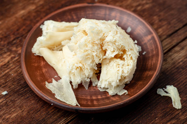 istock Hard cheese sliced chips on a clay plate on a wooden background. 1355679369