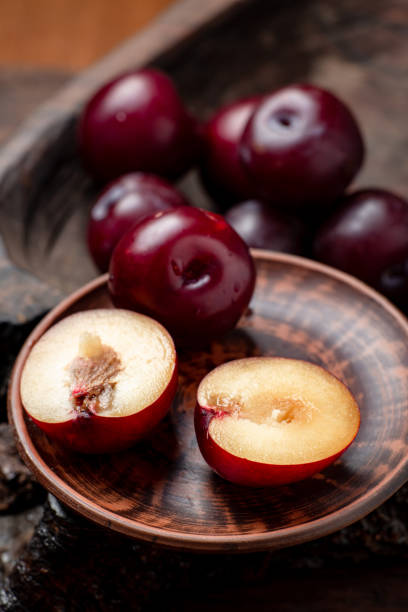 prugne rosse fresche affettate su uno sfondo di legno scuro. - red potato isolated raw potato raw foto e immagini stock