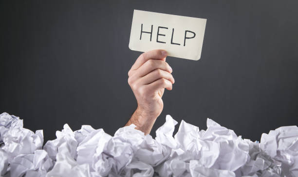 istock Male hand holding text Help with a crumpled papers. 1355680606