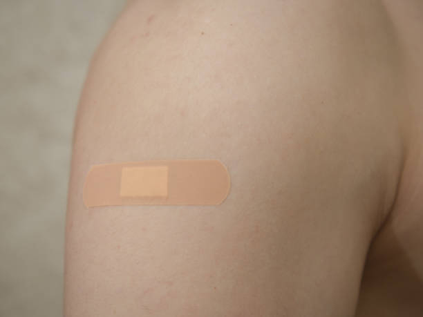 istock Man's shoulder with bandage plaster after vaccine injection. 1355680751