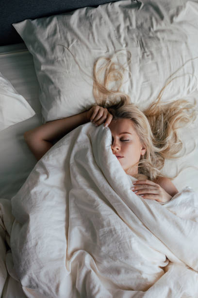 istock A Beautiful Blonde Sleeping Peacefully On Her Back, Covered Partially With A Blanket 1355681566