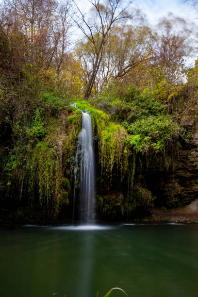 istock Beautiful waterfall Bourbon with a lagoon in the autumn forest. 1355681786