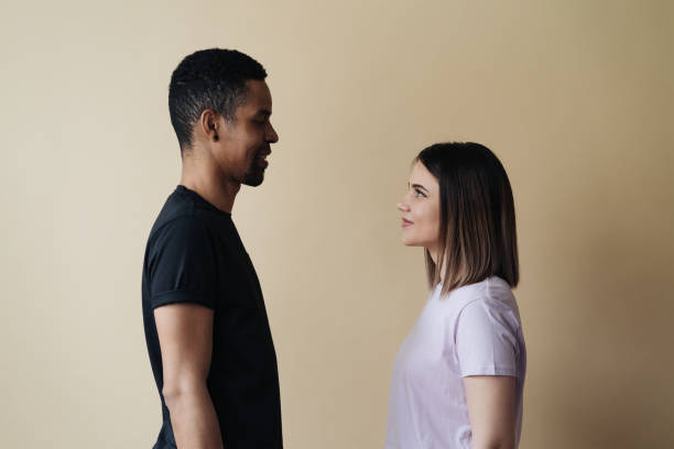 istock Mixed race couple look each at other on beige background 1355682214
