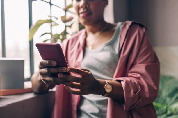 istock Anonymous Cuban Female Artist Wearing a Pink Shirt, Using her Mobile Phone in her Studio 1355683016