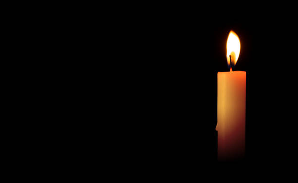 istock Burning candles on a black background. Blank space for inserting text. Ritual commemorations 1355683462