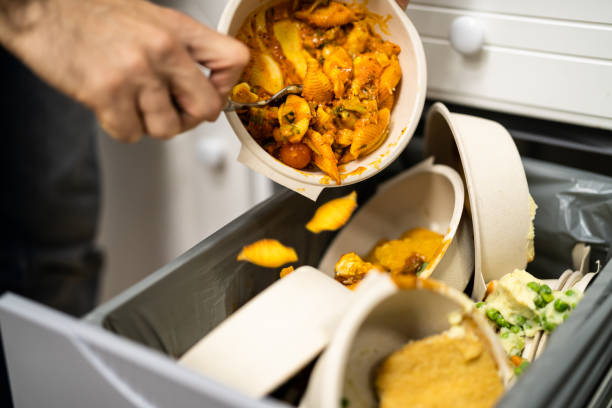 Throwing Away Leftover Food In Trash stock photo