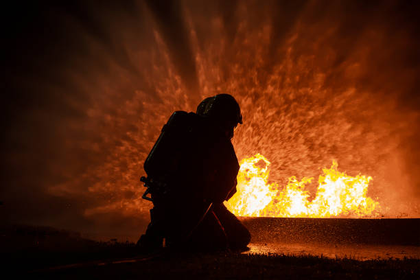 istock Firefighter training, fireman using water and extinguisher to fighting with fire flame in an emergency situation., under danger situation all firemen wearing fire fighter suit for safety. 1355684657