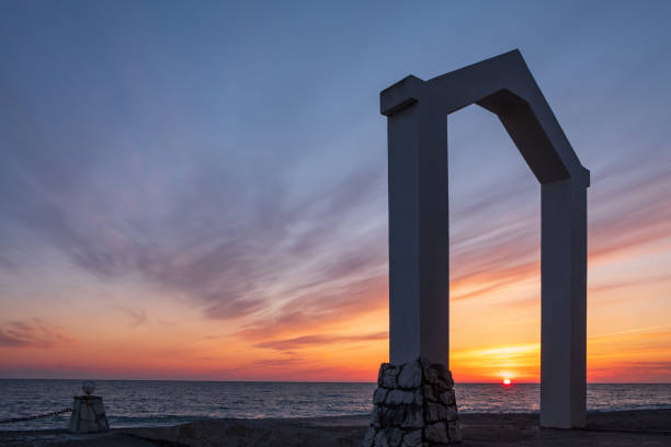 istock the seashore during sunset, the horizon line and the triangular arch in the foreground 1355685036