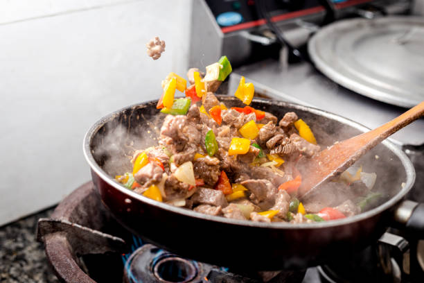 istock the chef is shaking the pan with meat and vegetables 1355686258