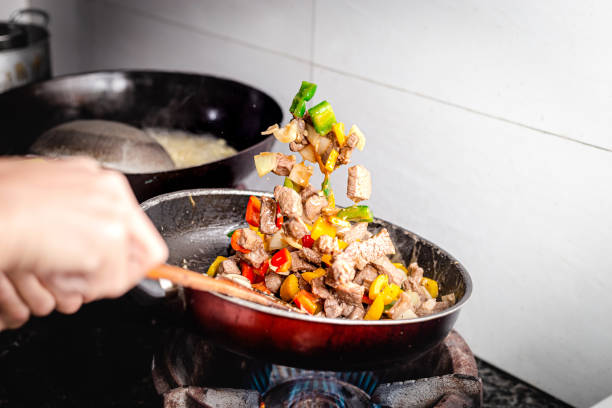 istock the chef is shaking the pan with meat and vegetables 1355686259