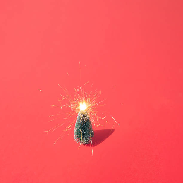 istock New Year Christmas tree with fireworks on a red pastel background. 1355686374