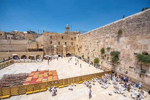 Jerusalem, Israel - November 11, 2021: People praying while facing the Western Wall, also known as Wailing Wall, in the Old City of Jerusalem.