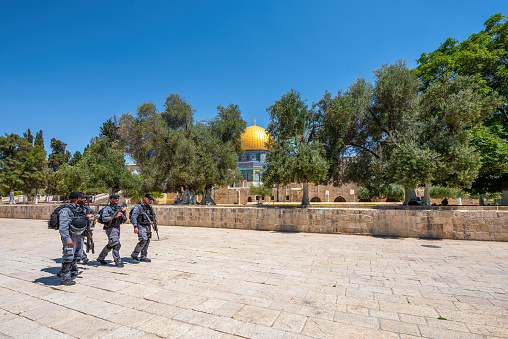 Jerusalem, Israel - November 11, 2021: Heavily armed Israeli security forces walking by the famous Al-Aqsa Mosque in Jerusalem.