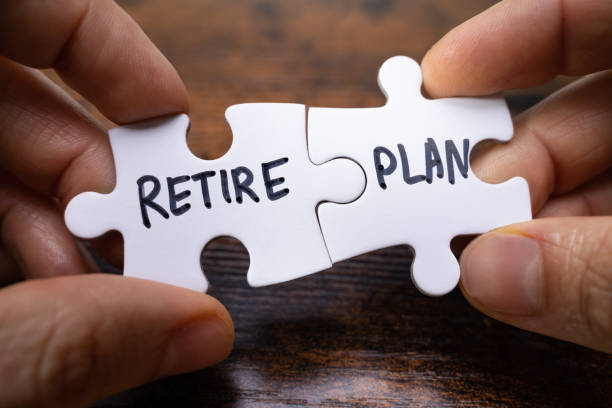 istock Hands Holding Retire Plan Matching Jigsaw Pieces Against 1355687776