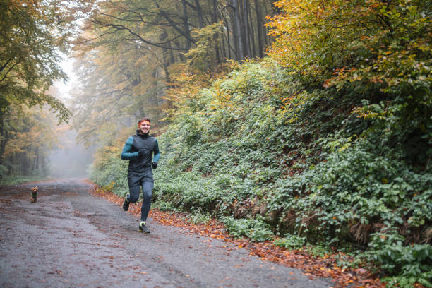 istock Man Jogging With His Dog In Autumn 1355688807