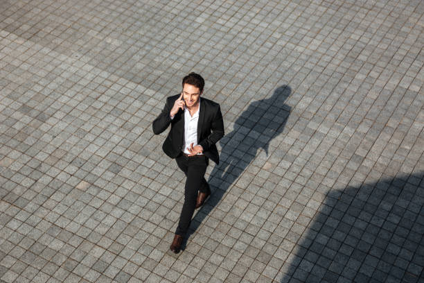 istock Happy young businessman walking outdoors 1355689751