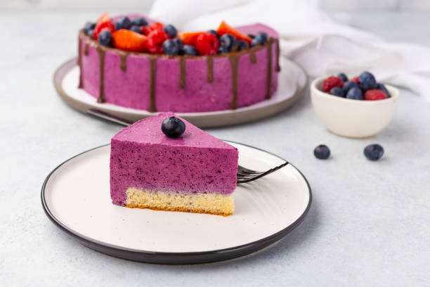 istock Slice of delicious blueberry cheesecake on white plate, light table 1355691133