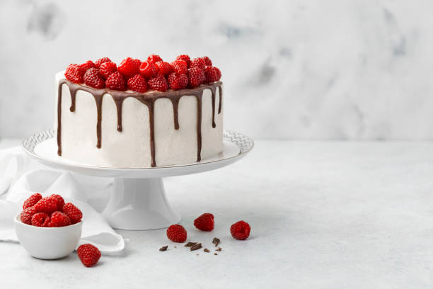 pastel de frambuesa con glaseado de chocolate en soporte para pastel - tart dessert plate white fotografías e imágenes de stock