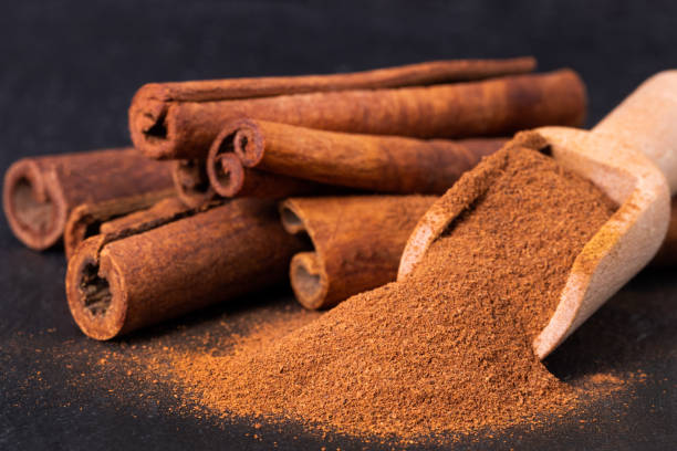 istock Cinnamon sticks and powder on dark background 1355691901