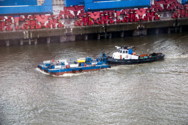small tug boat relase the cables after pulling the big ship trough the maas river in Holland
