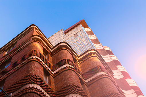 Fragment of the facade of a modern residential building made of bricks - abstract background.