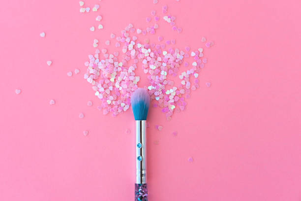 istock Makeup brush and shiny pink sequins on a pink background. Festive magic makeup concept. Template for design, top view Flat Lay Copy space. 1355693489